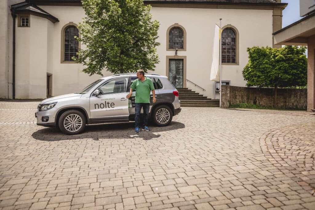 Mitarbeiter steigt aus Nolte Pflege Fahrzeug aus